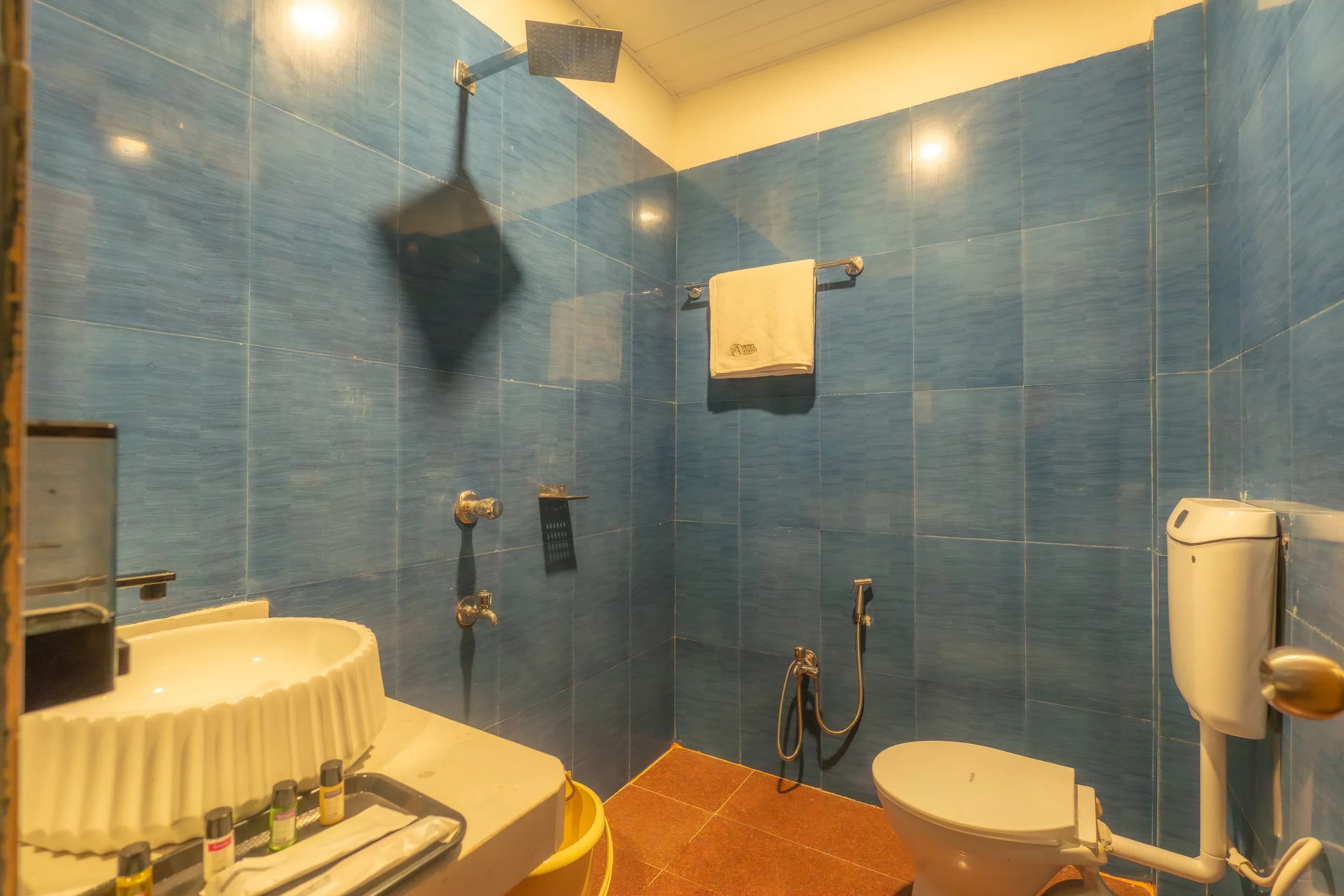 Blue-tiled bathroom with a basin, mirror and shower
