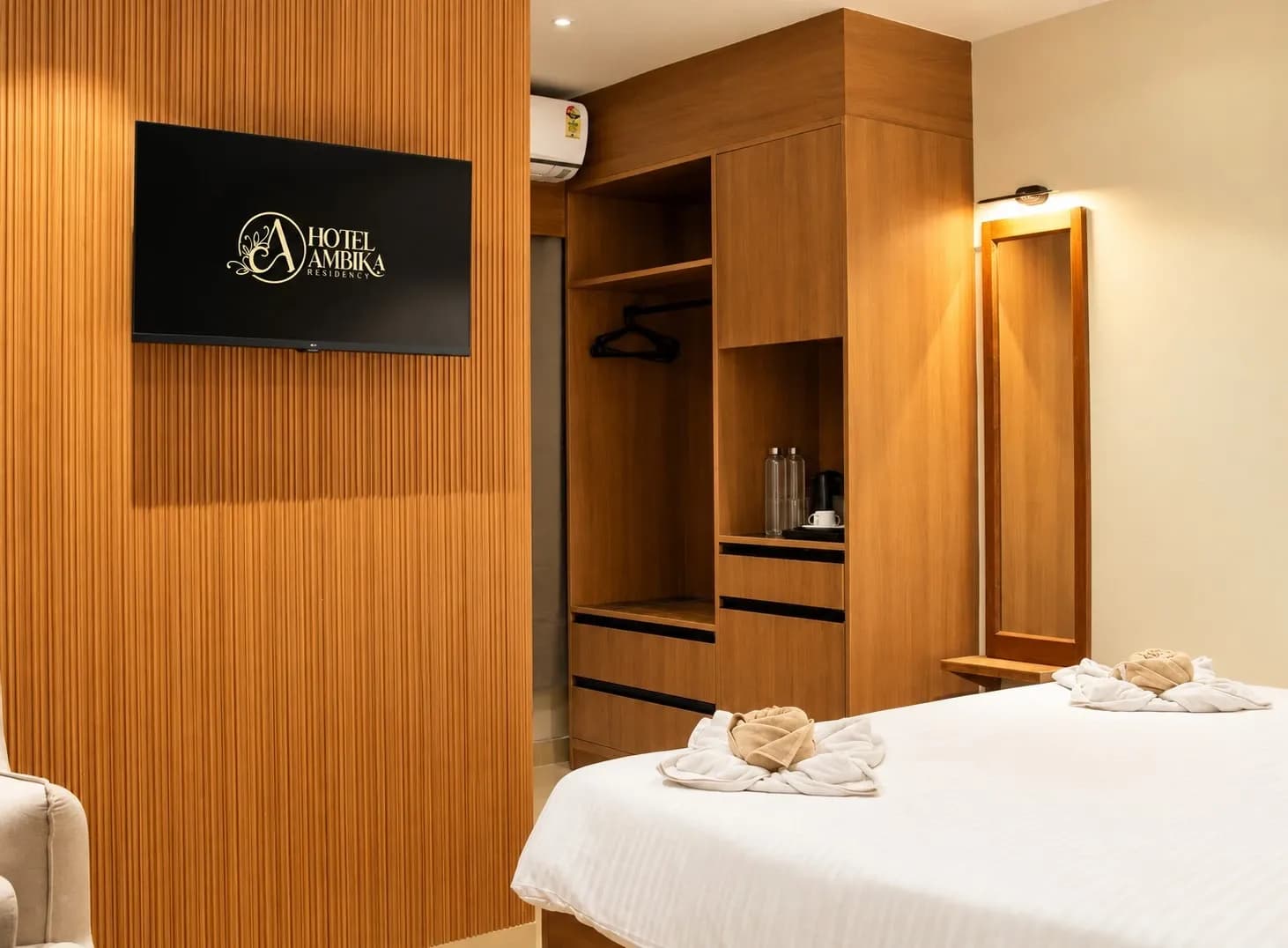 Guest room television partition facing the open wardrobe and illuminated mirror