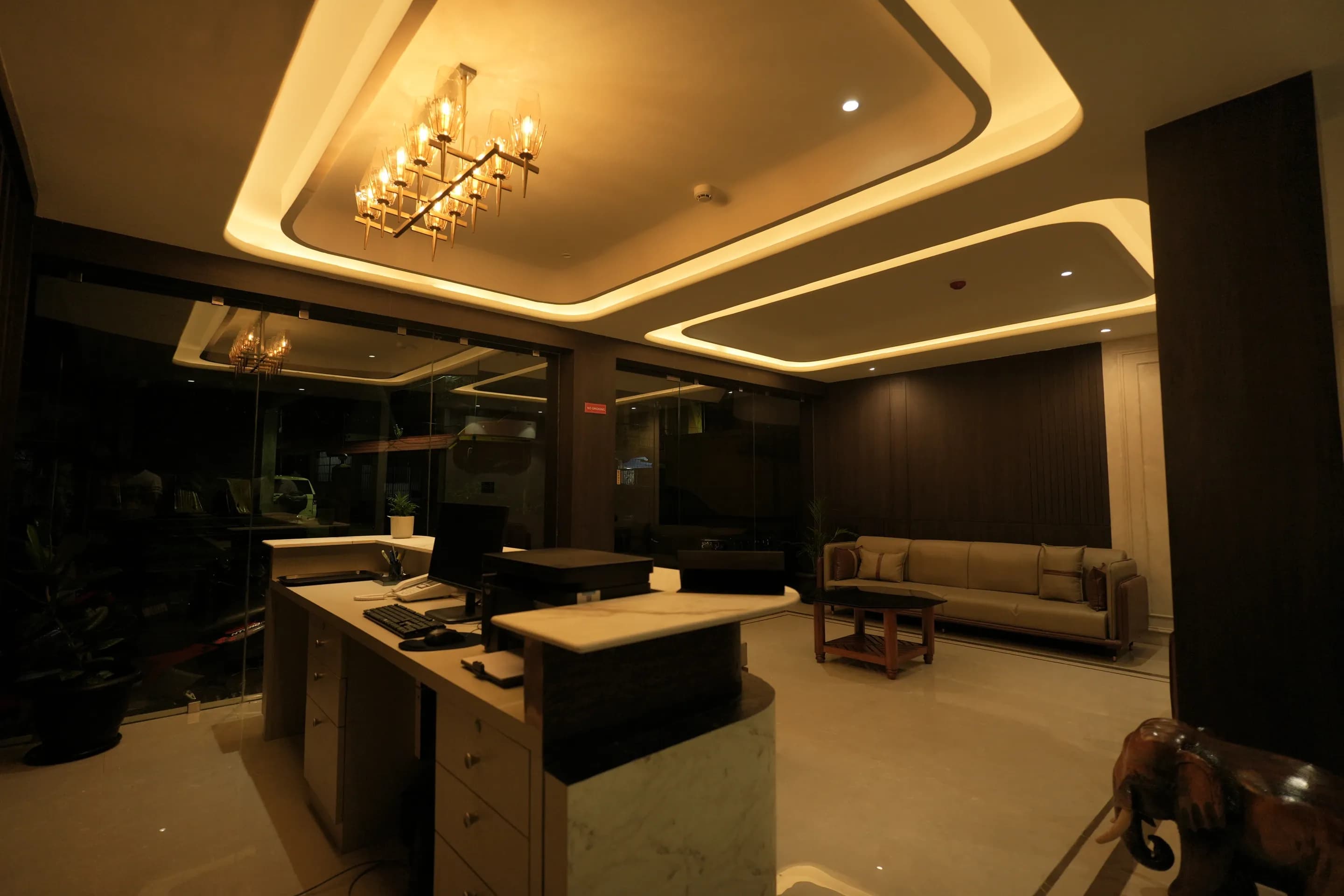 View from behind the reception counter towards the chandelier and lobby seating