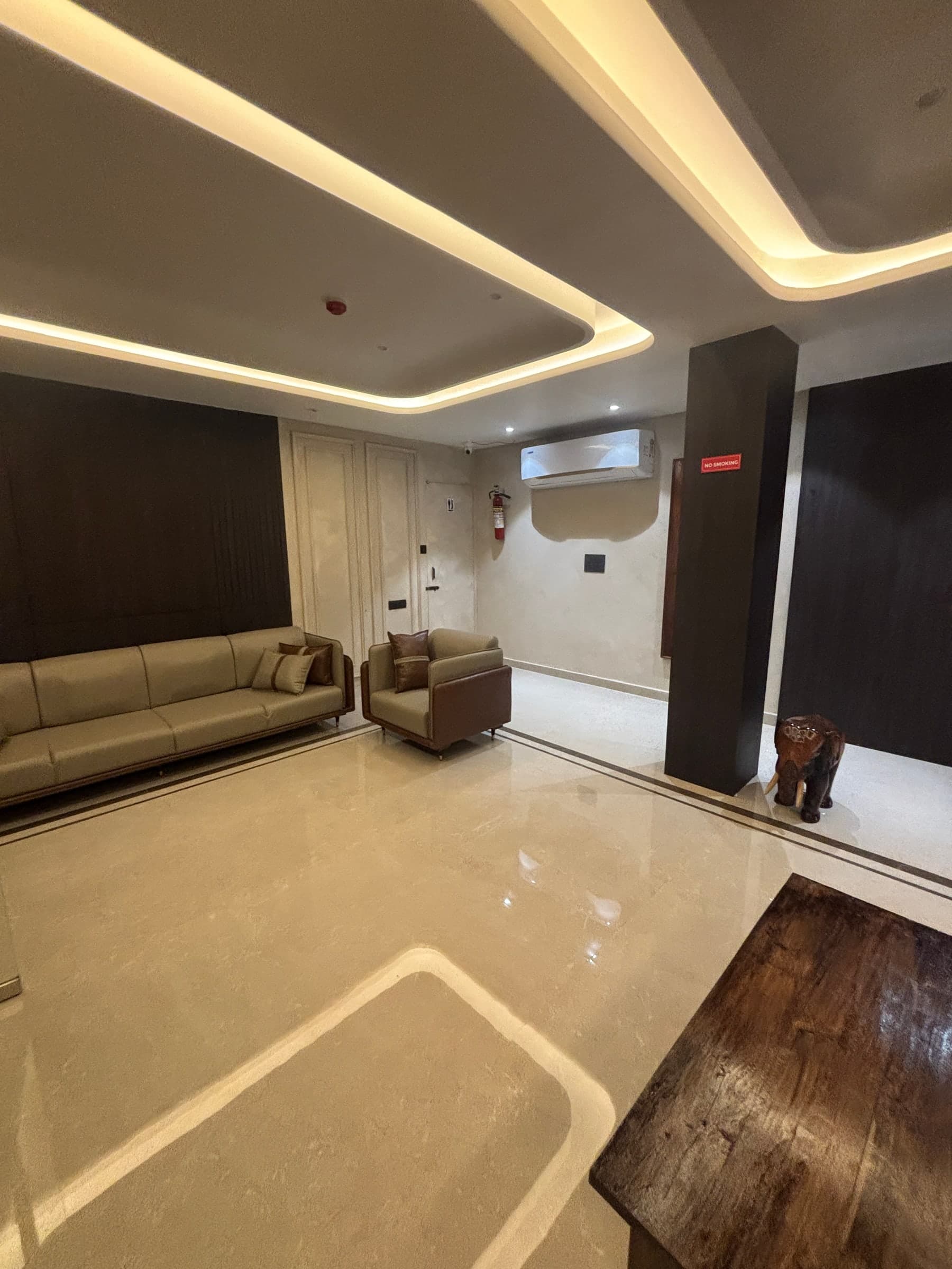 Warmly lit lounge seating inside Ambika Residency