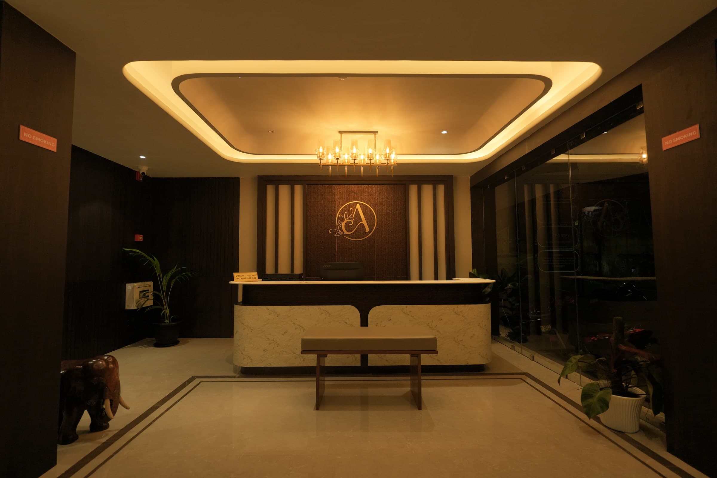 The Ambika monogram on the textured timber reception wall