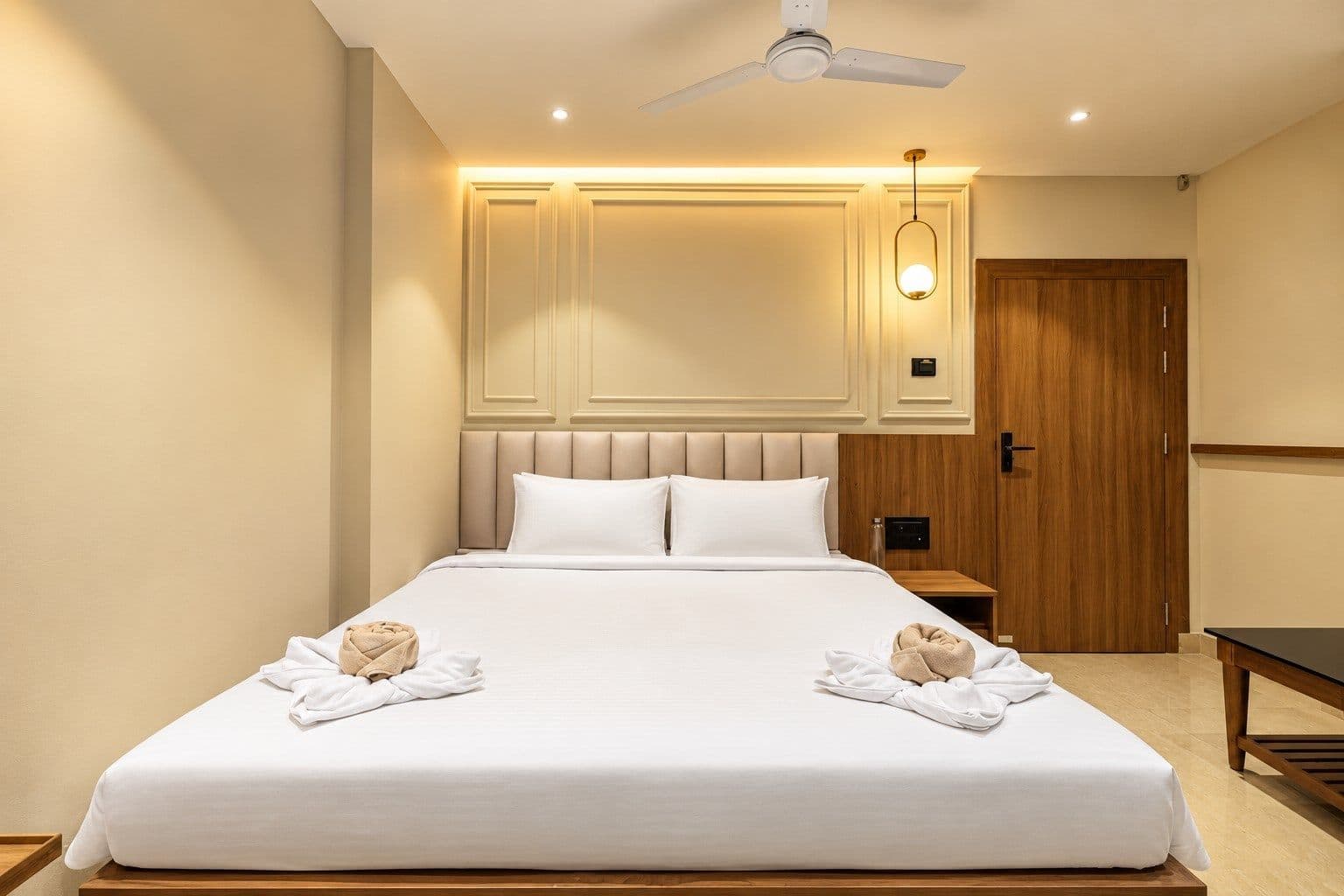 A Standard Room bedroom with a wood-panelled headboard and neatly made bed